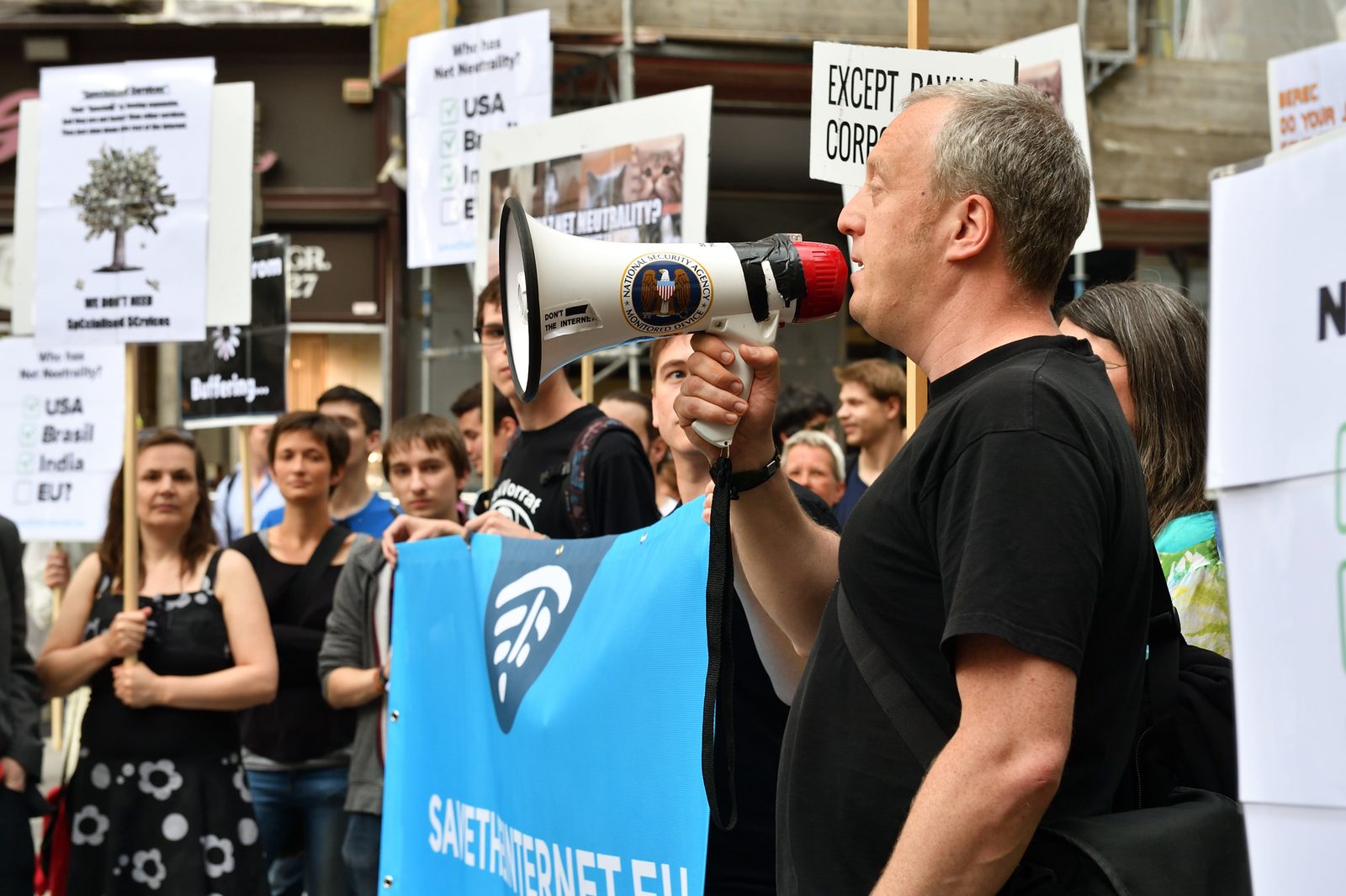 Man shouting into a megaphone decorated as an NSA surveillance device at the 2016 Vienna save-the-internet protest