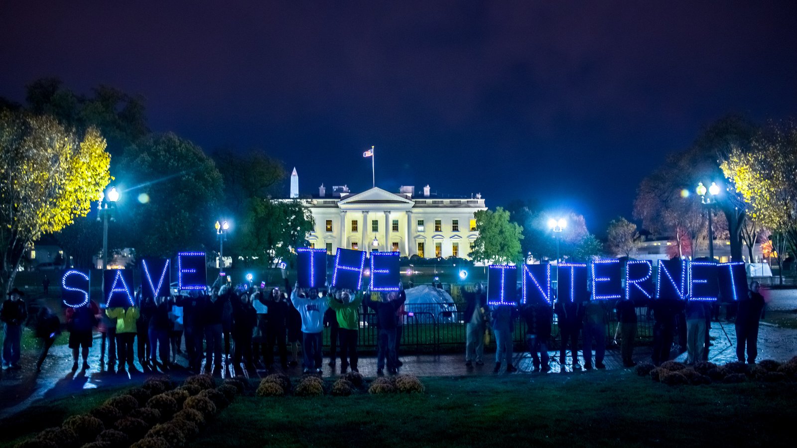 Activists spelling out &ldquo;SAVE THE INTERNET&rdquo; in illuminated letters in front of the White House at night